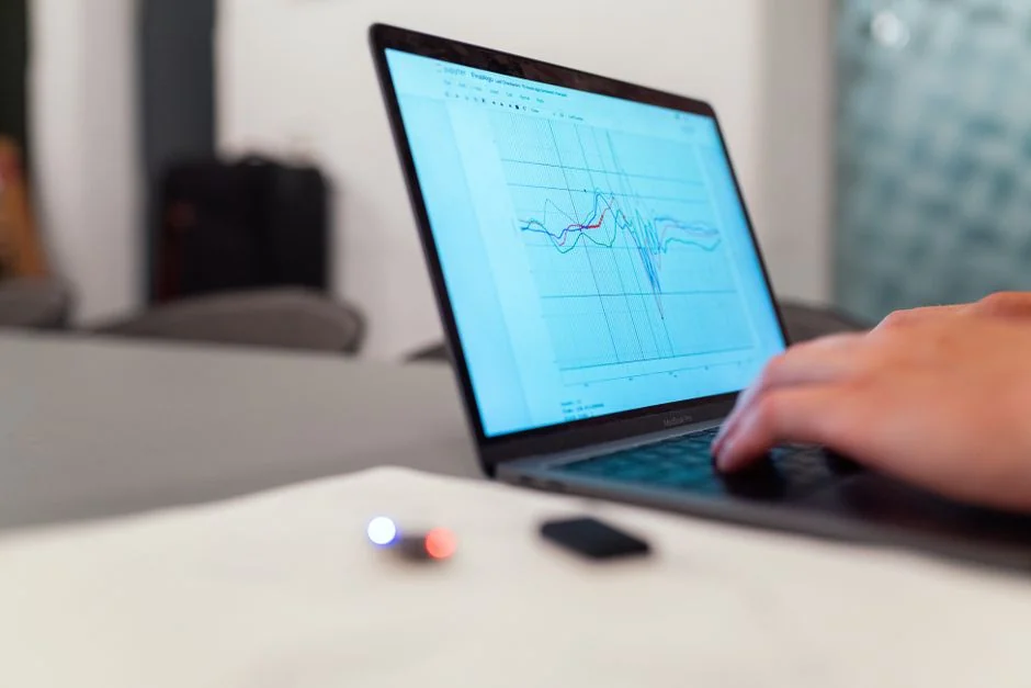 Overhead view of a laptop displaying data visualizations and charts on its screen.